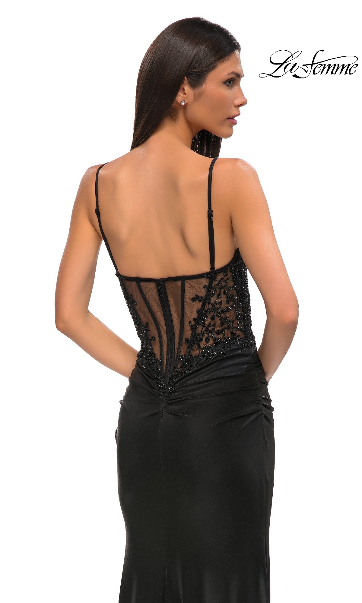 A woman models the Lace-Corset Long Jersey Prom Dress: La Femme 32803, featuring thin straps and a sheer, beaded-lace corset back. The